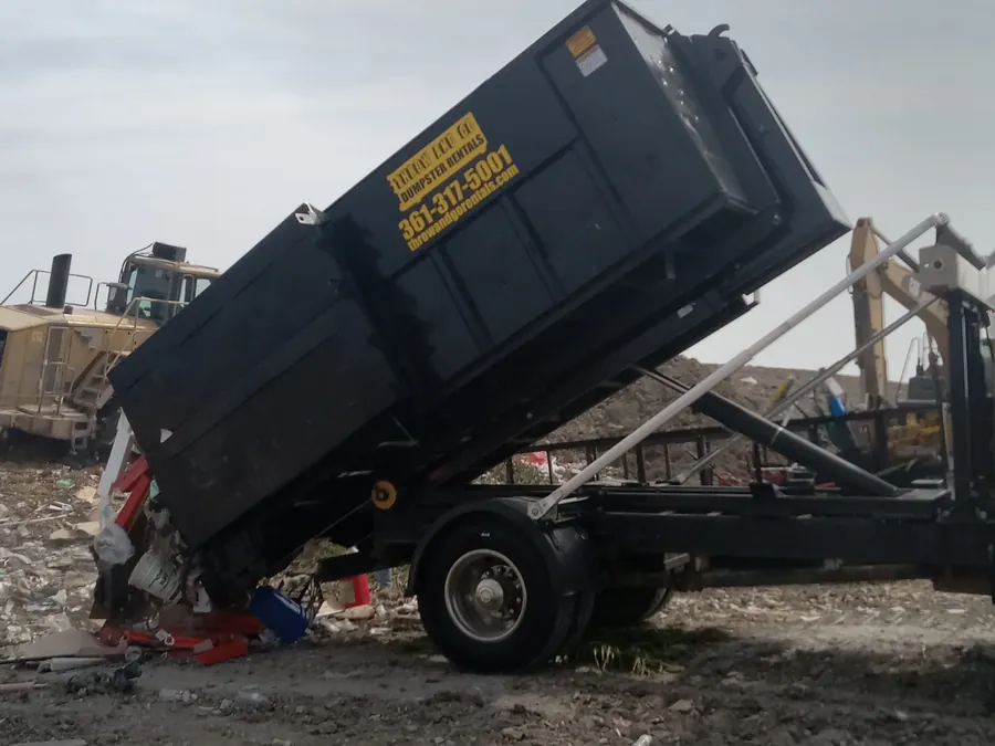 Throw and Go truck unloading a roll-off dumpster at the transfer station near Corpus Christi