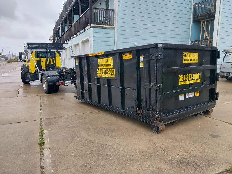 Throw and Go roll-off dumpster set on a concrete driveway at a Corpus Christi home